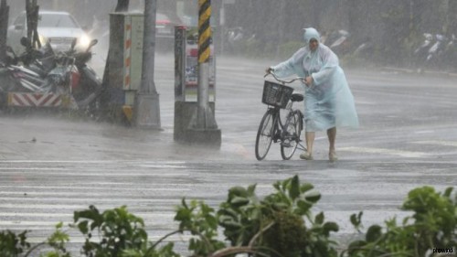 台风在台湾多地带来强风暴雨，这是台北市一名市民在风雨中前行